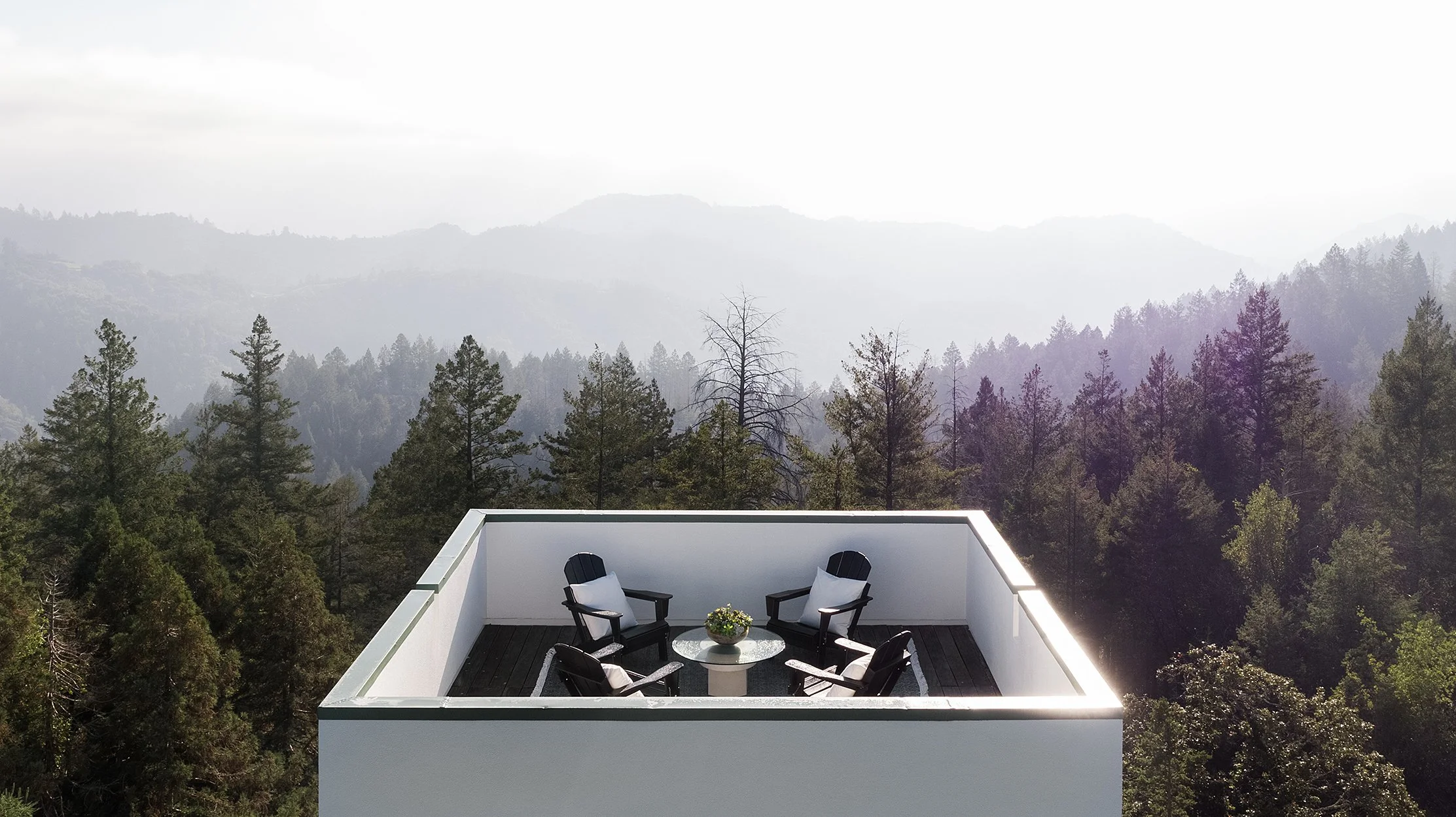 Rooftop deck seating overlooking misty mountain forest